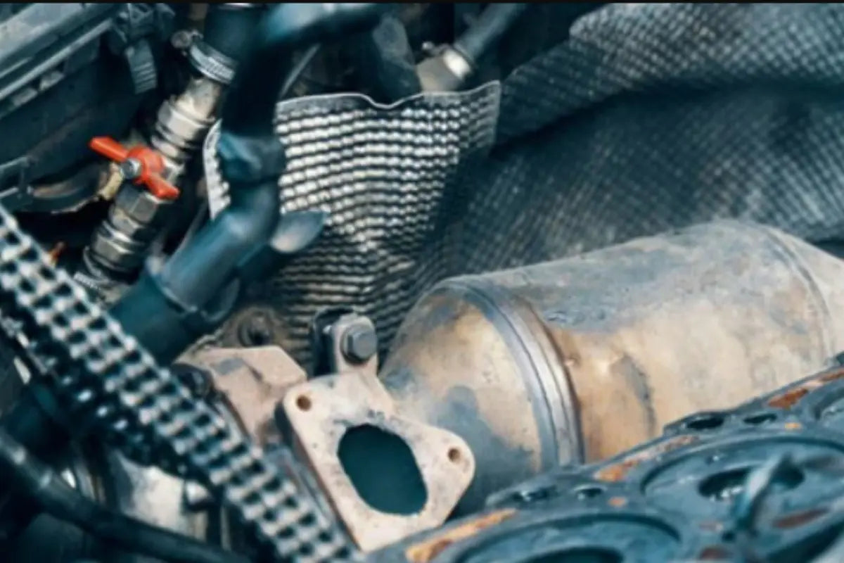 Mechanic inspecting DPF delete pipe installation on diesel truck